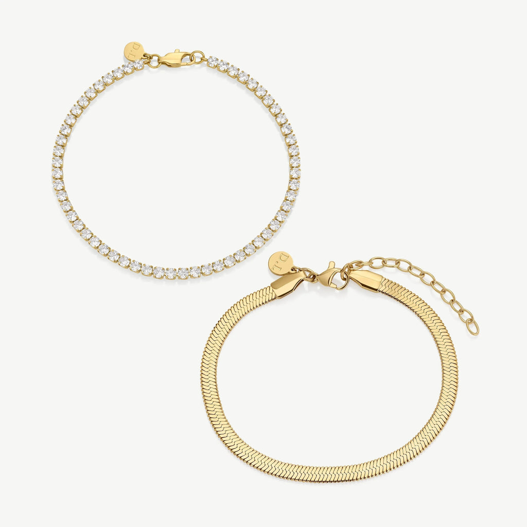 Two gold bracelets on white background, one with sparkling clear stones, one with smooth snake chain