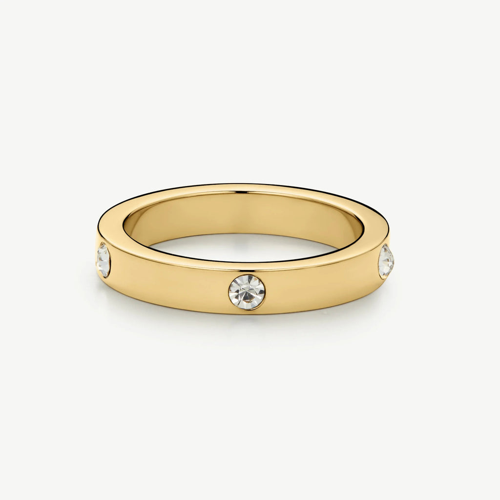 Gold ring with three embedded round clear gemstones on a white background