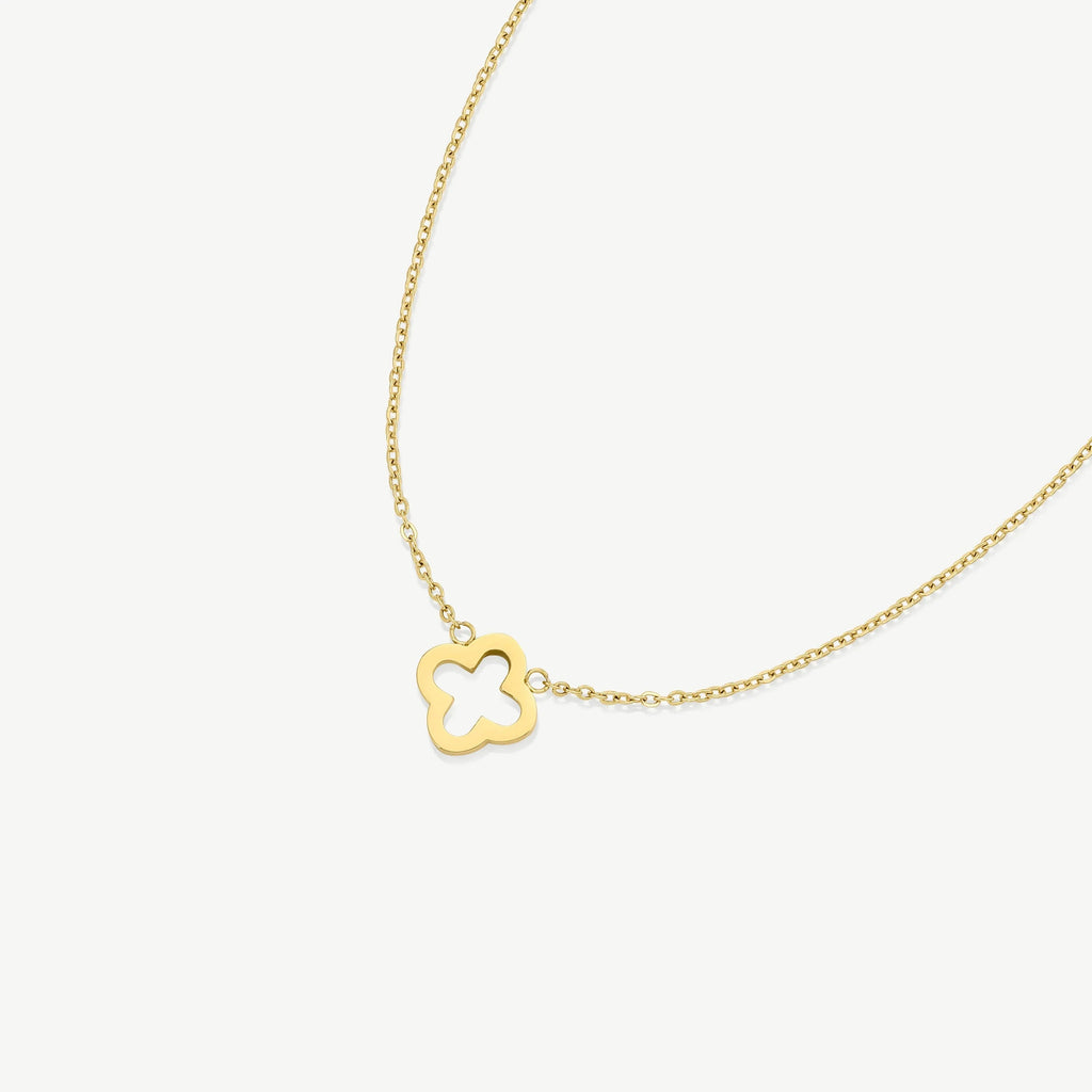 Gold chain necklace with small quatrefoil pendant on white background