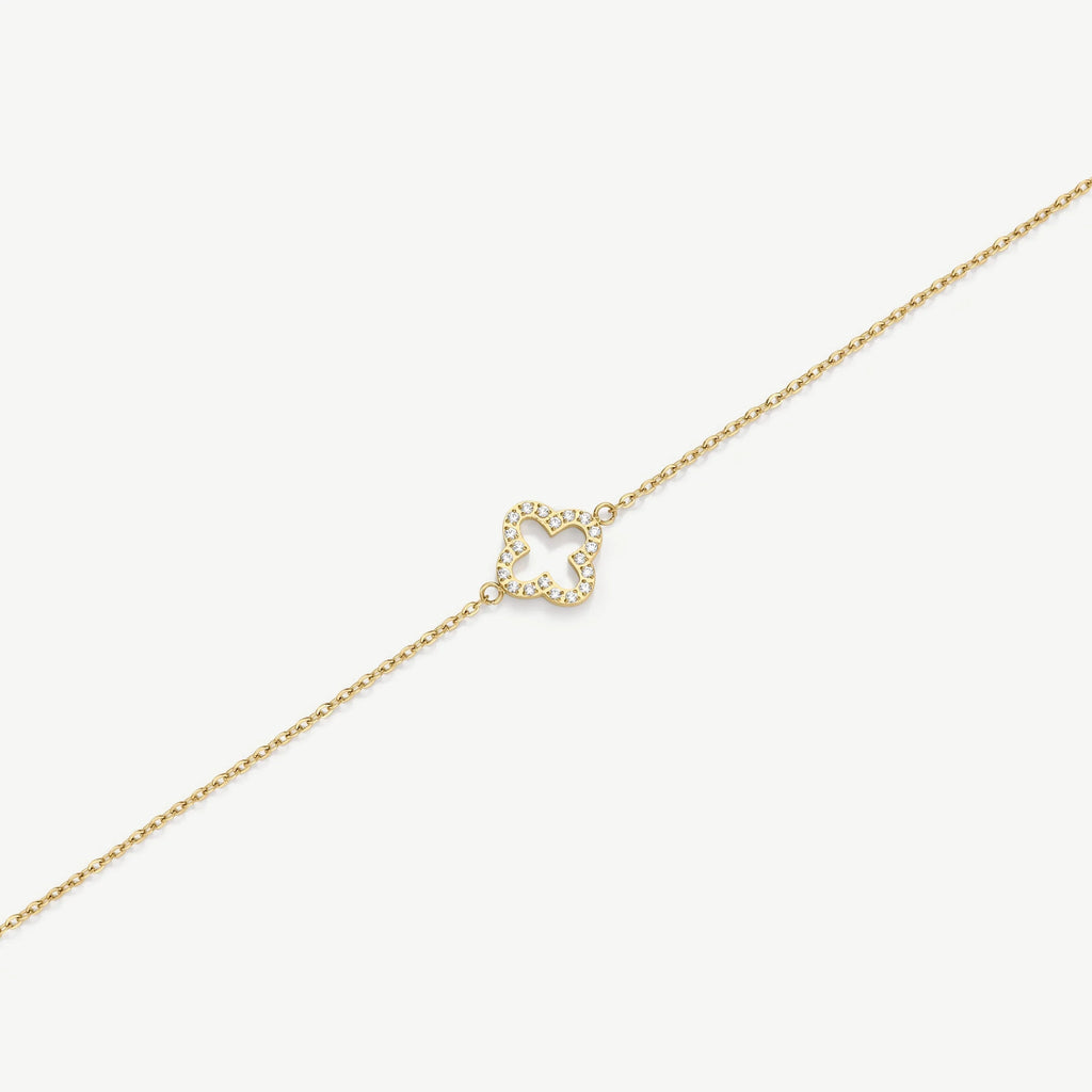 Gold chain bracelet with diamond-encrusted clover-shaped charm on white background