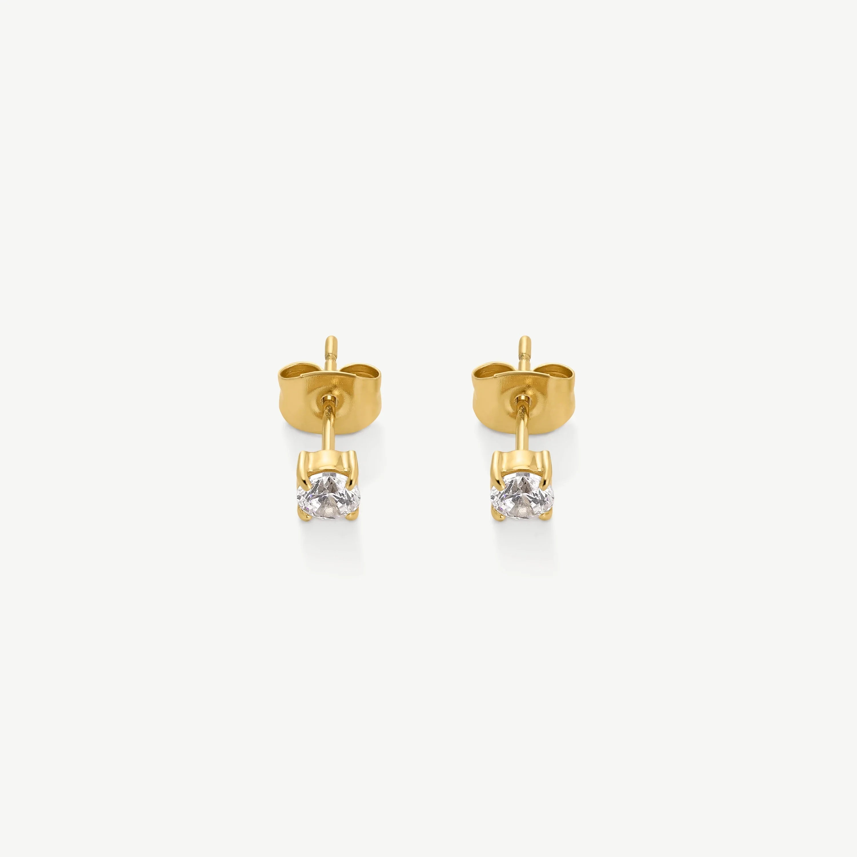 Pair of gold stud earrings with clear round-cut gemstones on white background