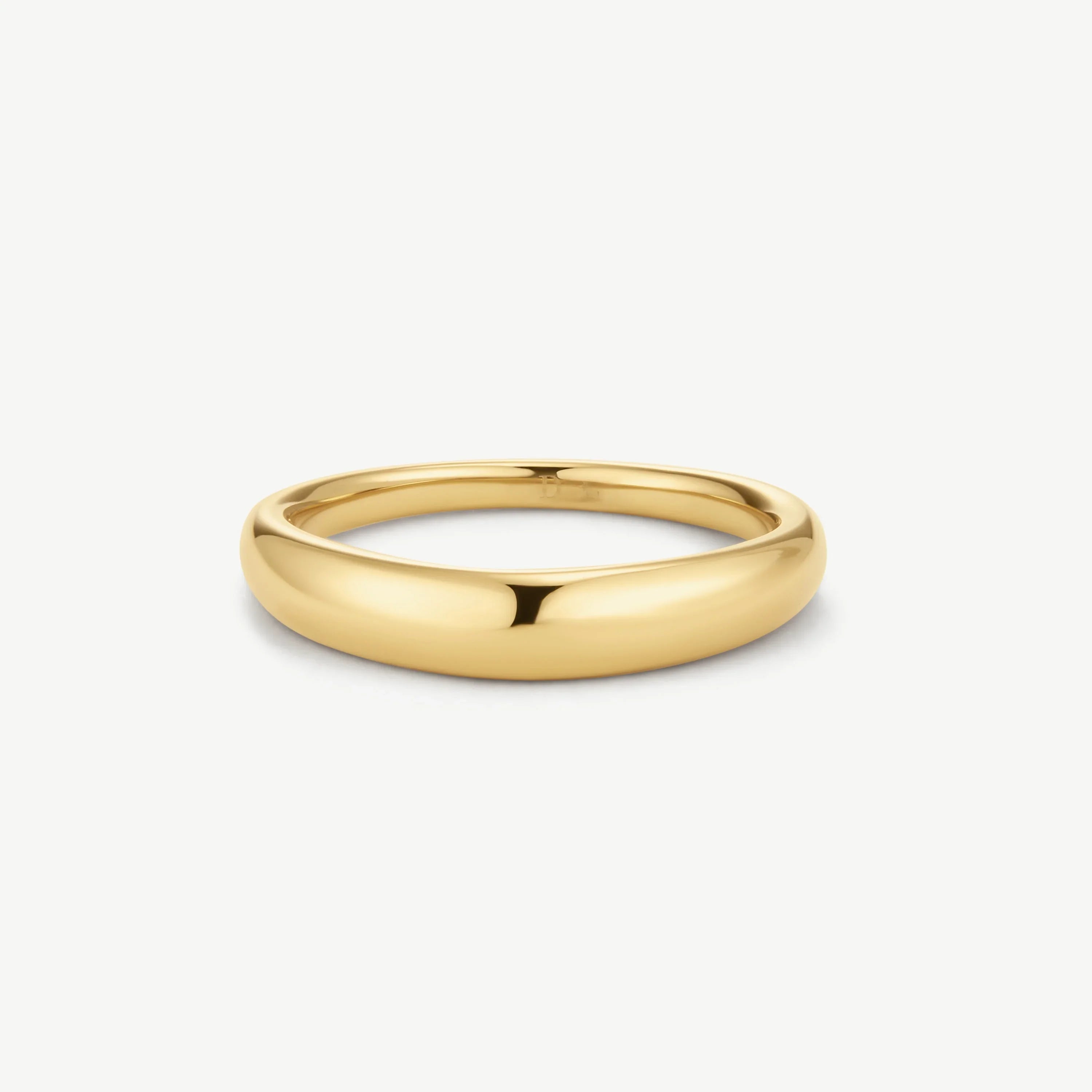 Polished gold dome-shaped ring on white background, sleek minimal jewelry