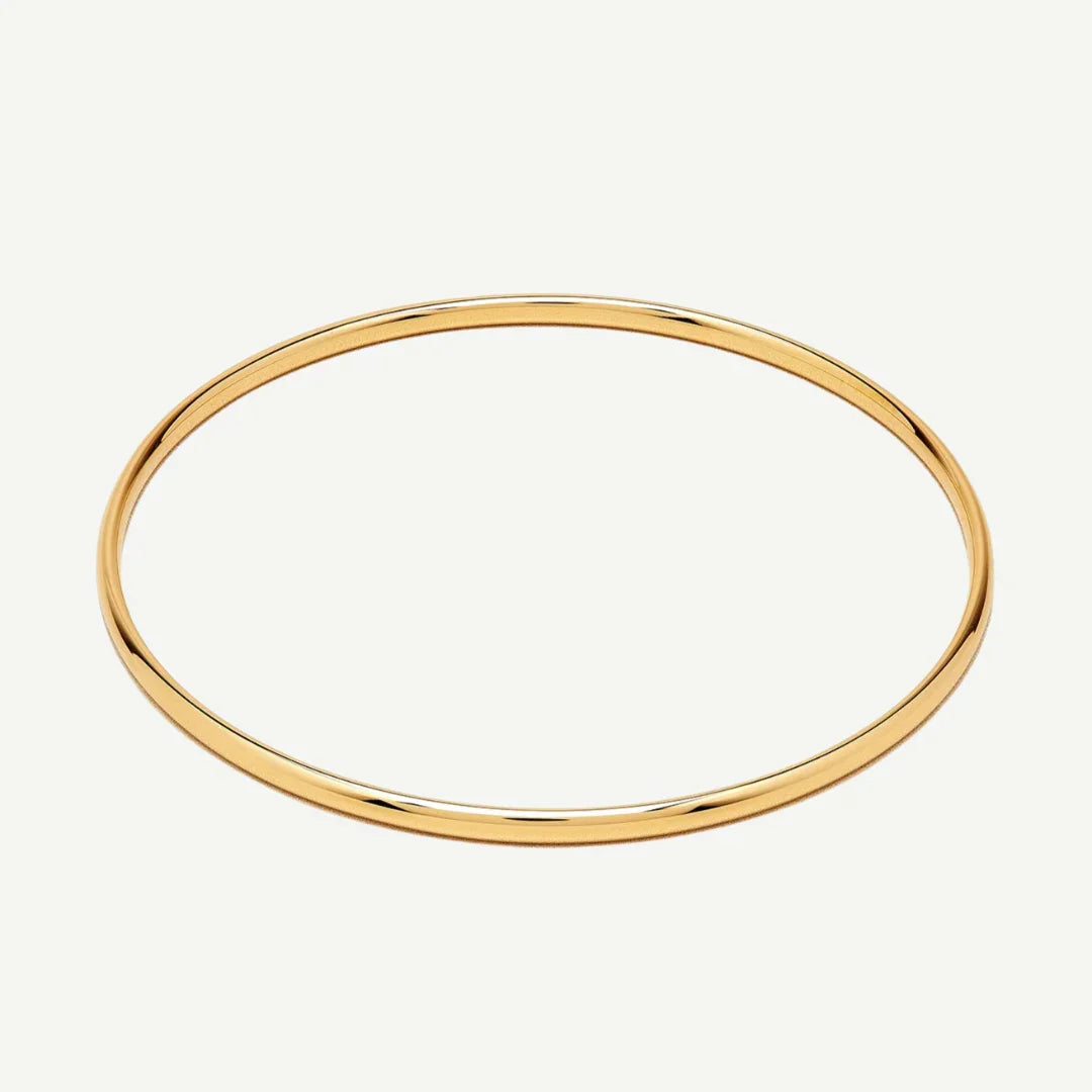 Thin polished gold bangle bracelet on white background