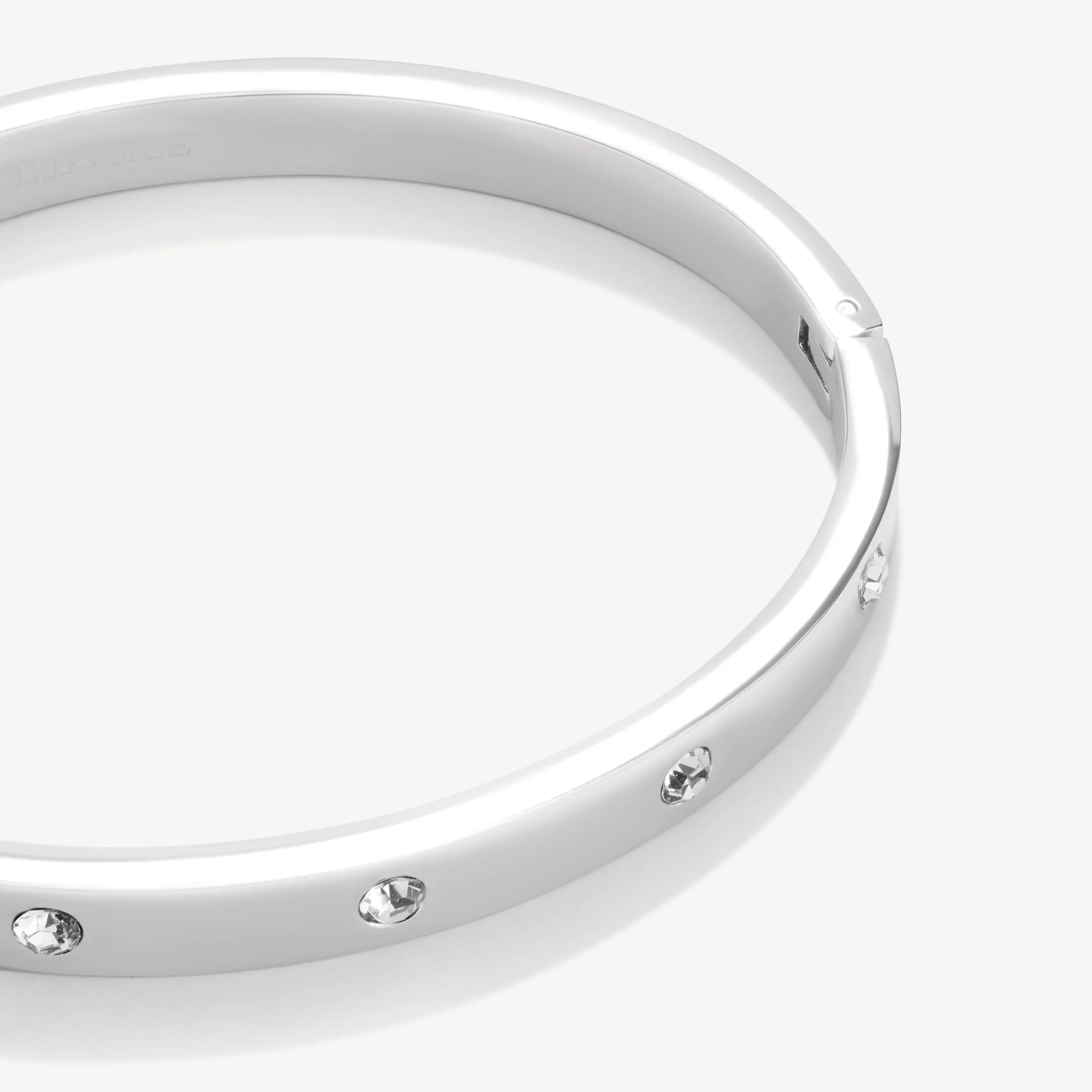 Silver bracelet with embedded clear crystals on white background