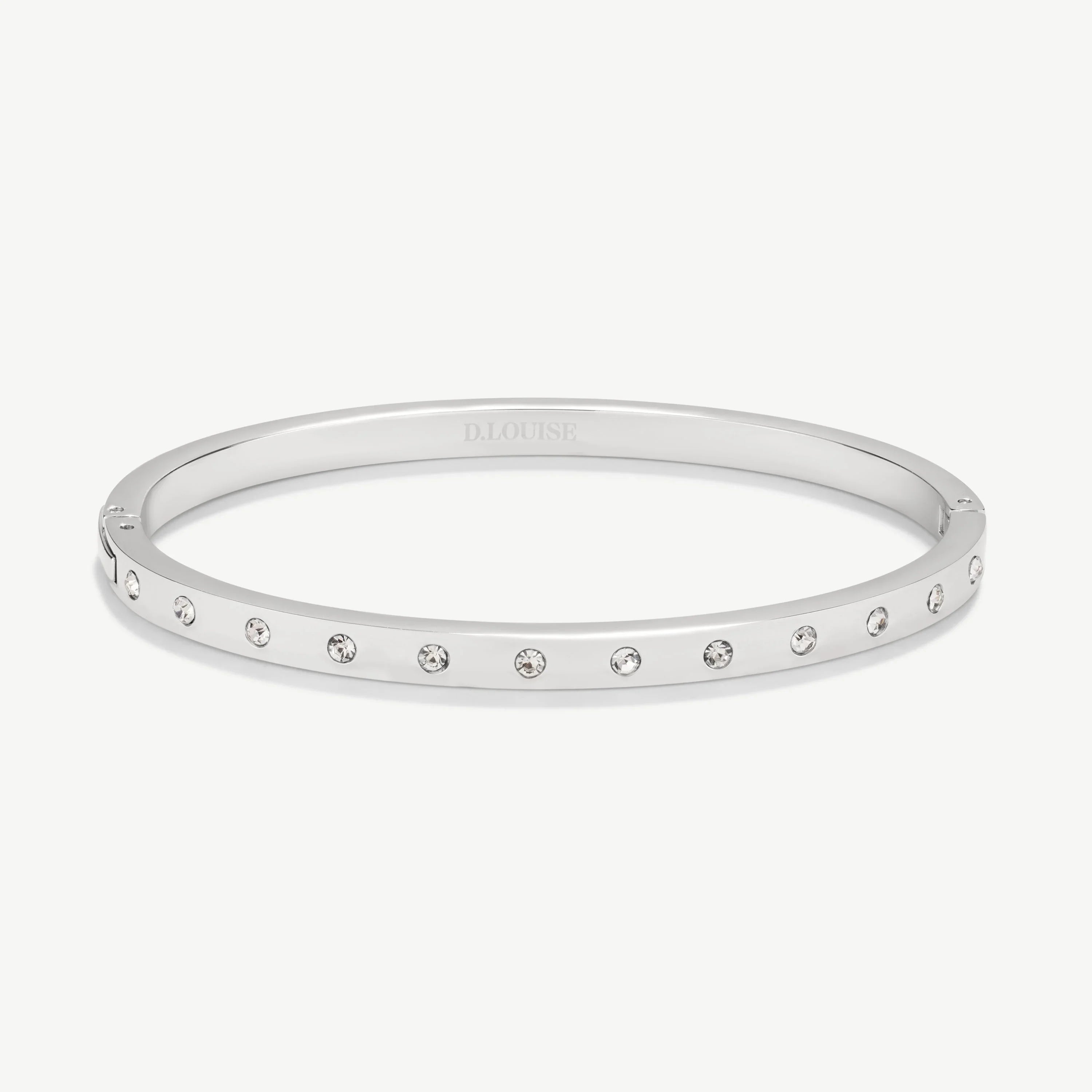 Silver bangle bracelet with evenly spaced clear crystals on white background