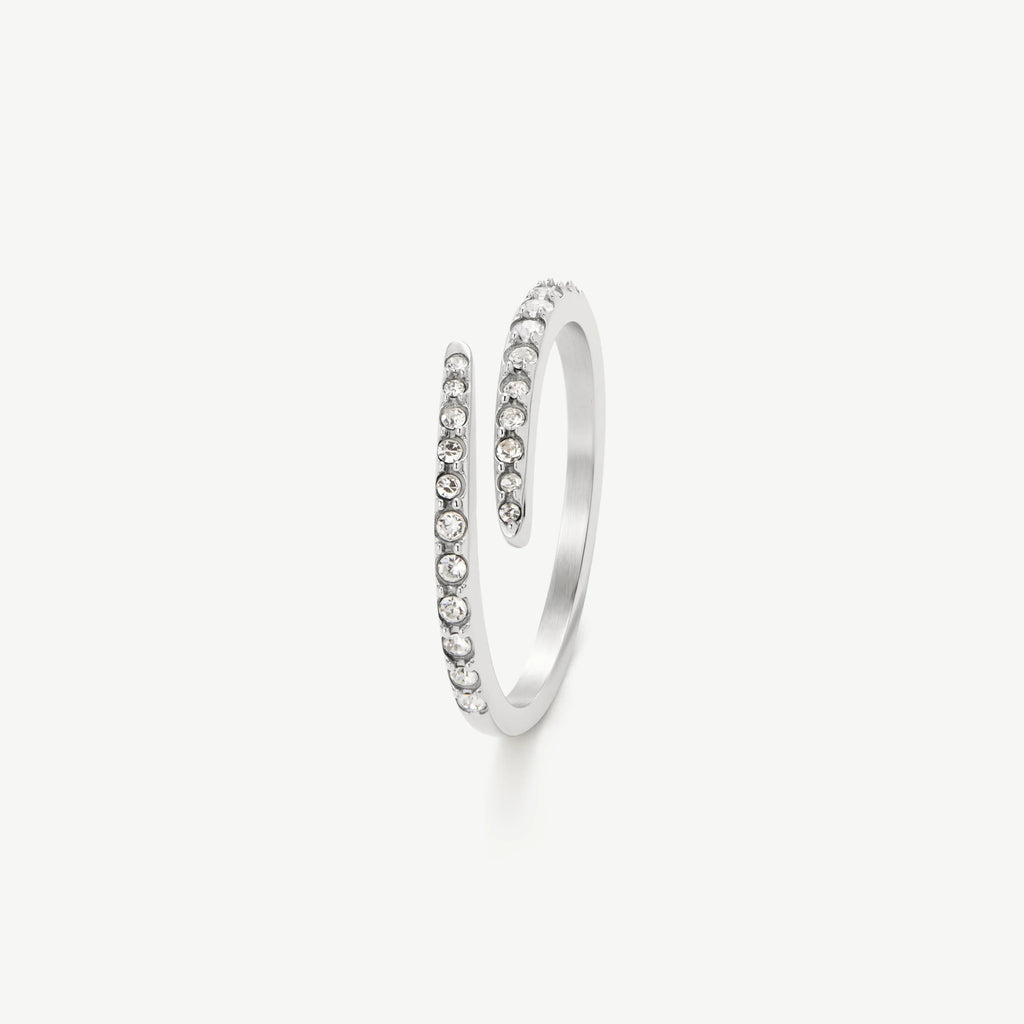 Silver open spiral ring with small clear crystals on a white background
